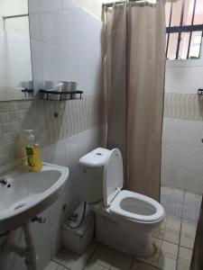 a white bathroom with a toilet and a sink at Zariah Homes 1 in Kakamega