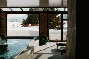 a swimming pool with a view of a snow covered slope at Mountain Lodge & Spa, Les Crosets in Les Crosets