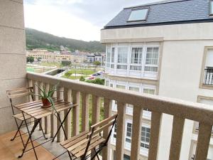 a balcony with two chairs and a table at Praia - Boa Onda in Cee