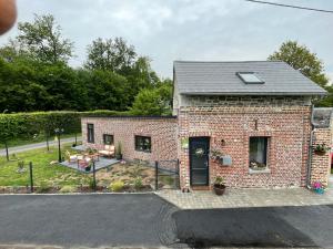 a brick house with a patio and a yard at Le gîte des Romains in Anor