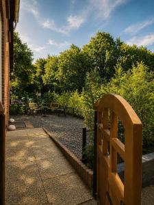 a wooden gate to a garden with a table and benches at 'tNest Middelaar in Middelaar