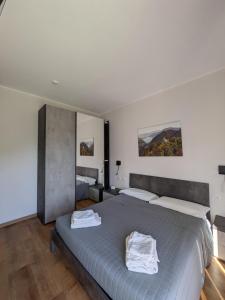 ein Schlafzimmer mit einem Bett, auf dem zwei weiße Handtücher liegen in der Unterkunft EderaRooms in Cerano d'Intelvi