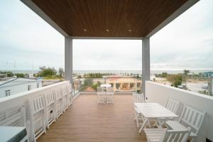 a balcony with white chairs and tables and a view at ANNA Boutique Villa - Sea View in Phan Thiet