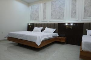 a bedroom with a bed with white sheets and windows at Radiant Inn in Morena