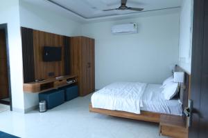 a bedroom with a bed and a tv on a wall at Radiant Inn in Morena