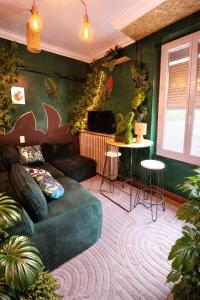 a living room with a couch and a table at Le Studio Jungle climatisé in Graulhet