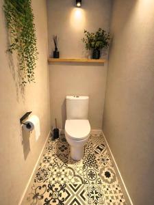 a bathroom with a toilet and a tiled floor at Le Studio Jungle climatisé in Graulhet