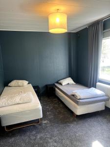 two beds in a room with a blue wall at Stor villa med jacuzzi in Herräng