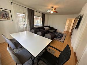 a living room with a white table and chairs at Stor villa med jacuzzi in Herräng +12 photos