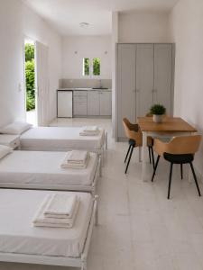 a room with four beds and a table and a dining room at Orama Studios in Plakias