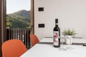 a bottle of wine sitting on a table with two glasses at ChaletMafi in Valdidentro