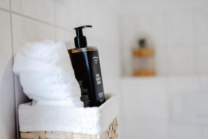 a bottle of soap sitting on top of a pile of towels at HarzHold - Apartmenthotel in Osterode