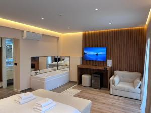 a hotel room with a bed and a tub and a television at Hotel Vila Ami in Tragjas