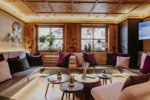 a living room with a couch and tables at Hotel zur Pfeffermühle in Sankt Anton am Arlberg