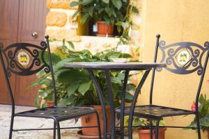 a black table and two chairs next to a plant at BeB Omare Agrigento in Agrigento