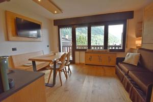 a living room with a couch and a table at Presanella View Studio Mhd in Madonna di Campiglio