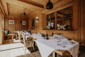 a dining room with white tables and chairs at Hotel zur Pfeffermühle in Sankt Anton am Arlberg