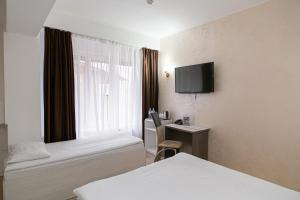 a hotel room with a bed and a desk at Astra City Hotel in Almaty
