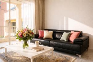 a living room with a black leather couch and a table at Princess Palace Monaco in Monte Carlo +7 photos