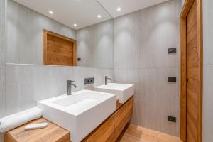 a bathroom with two sinks and a mirror at BRENTA ALTA ALPINE LODGE MhD in Madonna di Campiglio +57 photos