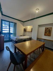 a room with a table and a bed and a bedroom at Central SPORT CAMPIGLIO 407 in Madonna di Campiglio