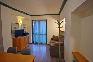 a living room with a tv and a couch and a table at Central SPORT CAMPIGLIO 407 in Madonna di Campiglio