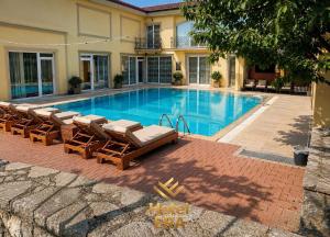 a swimming pool with lounge chairs next to a building at Hotel ERA in Prishtinë