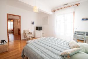 a bedroom with a large bed and a chair at CoTTAGE LA VILLA BOLERO in Saint-Cyr-sur-Loire +51 photos