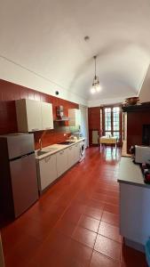 a kitchen with white appliances and a red tile floor at Cascinotto Stella Silvia in Piossasco
