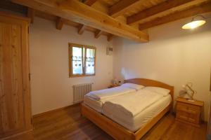 a bedroom with a bed and a window at Chalet Brenta Dolomites in Madonna di Campiglio