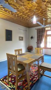 a wooden table and chairs in a room at Comfort Inn in Chitral