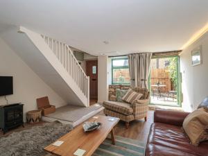 a living room with a couch and a table at Wheelwright Cottage in Moreton in Marsh