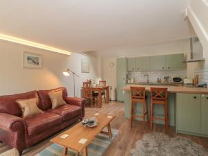 a living room with a couch and a kitchen at Wheelwright Cottage in Moreton in Marsh