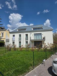 a white house with a fence in front of it at Moderne Sauerhof Apartments in Baden