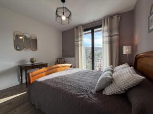 a bedroom with a bed and a large window at Iduzki-alde bi in Souraïde
