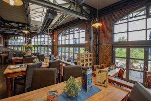 a restaurant with tables and chairs and windows at Hotel Dömitzer Hafen in Dömitz