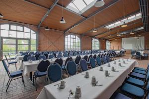 a row of tables and chairs in a large room with windows at Hotel Dömitzer Hafen in Dömitz +49 photos