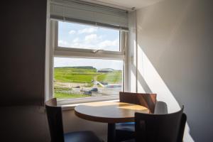 a table and chairs in front of a window at Tommy Jacks Beach Apartments in Bude