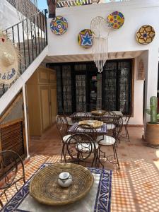 a patio with tables and chairs and plates on the wall at Riad Le Grizzly in Marrakesh