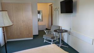 a room with a bed and a table and a chair at Hotel Garni Vindobona in Pörtschach am Wörthersee