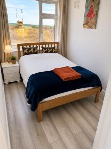a bedroom with a bed with a blue blanket and a window at 2BR Mariners Stay - Newhaven in Newhaven