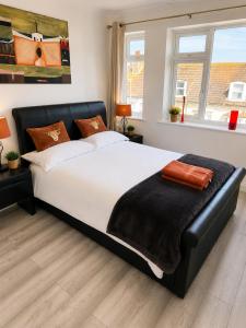 a bedroom with a large bed with a black leather headboard at 2BR Mariners Stay - Newhaven in Newhaven