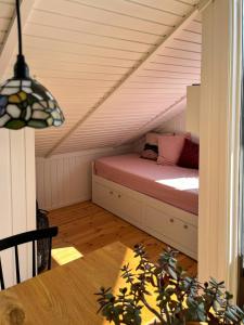 a attic room with a bed in the attic at Summer House With Authentic Charm On Enø in Karrebæksminde