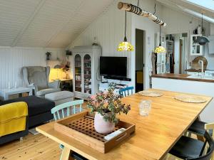 a kitchen and living room with a dining table at Summer House With Authentic Charm On Enø in Karrebæksminde