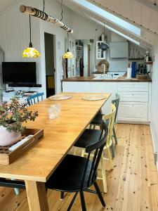 a large wooden table in a kitchen with chairs at Summer House With Authentic Charm On Enø in Karrebæksminde