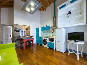 a kitchen with a living room with a table and a tv at Casas da villa - Apartments in Ericeira