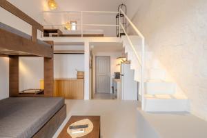 a room with a loft bed and a staircase at Jo&Co Mykonos Nature Suites N3 in Plintri