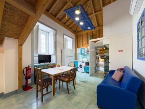 a living room with a table and a blue couch at Casas da villa - Apartments in Ericeira