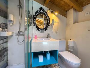 a bathroom with a sink and a toilet and a mirror at Casas da villa - Apartments in Ericeira +138 photos