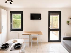 a living room with a table and a couch at Studio avec terrasse et jardin privatif - Figeac centre - Parking gratuit in Figeac